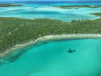 Aerial view of plane shadow in sea at exuma
