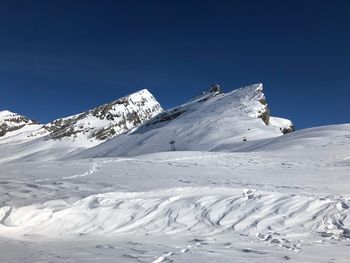 Scenic view of snowcapped mountains against clear blue sky