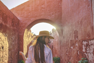 Rear view of woman standing in tunnel