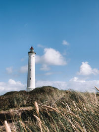 Lighthouse by sea against sky