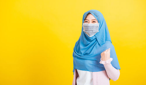 Muslim arab,  happy beautiful young woman islam wear veil hijab and face mask protect raise hands