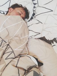 High angle view of man sleeping on bed