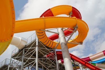 Low angle view of water slide against cloudy sky