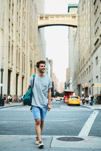 Portrait of young man standing on road in city