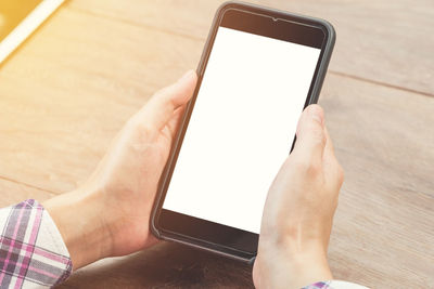 Midsection of person using mobile phone on table