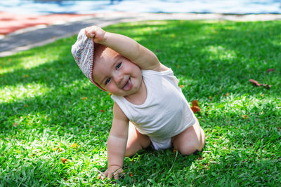 Lifestyle portrait of smiling baby girl in white clothing and panama.