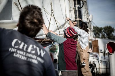 Rear view of crew working at harbor