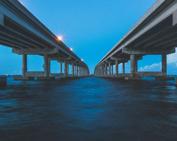 Low angle view of bridge over sea against clear sky