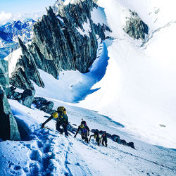 People skiing on snowcapped mountain during winter