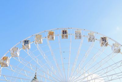 Low angle view of ferris wheel against clear blue sky