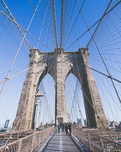 Low angle view of suspension bridge against blue sky