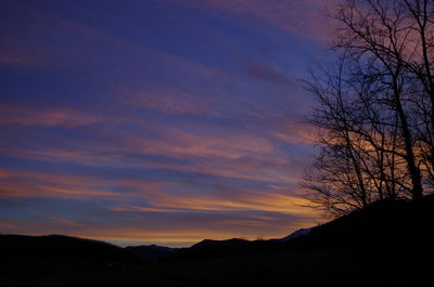 Scenic view of silhouette mountains against orange sky