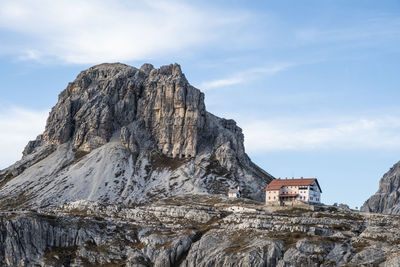 Rock formation by buildings against sky