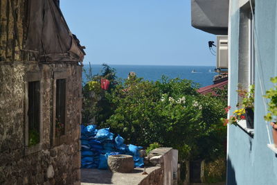 Scenic view of sea by building against clear blue sky