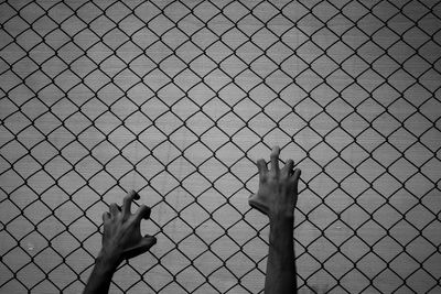 Close-up of hand on chainlink fence