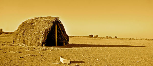 View of grass hut against clear sky