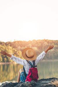 Rear view of woman with arms raised