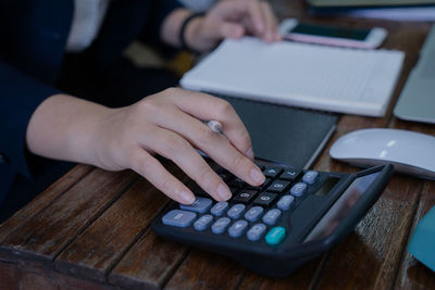 Midsection of woman reading book on table