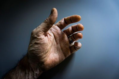 Cropped image of hand against blue background