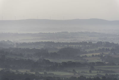 Scenic view of landscape against sky at foggy weather