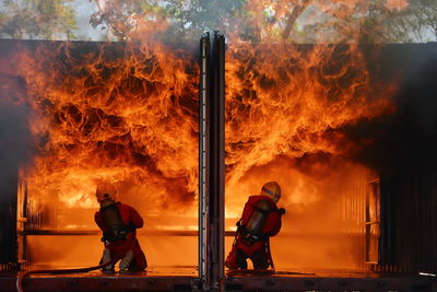 Men with fire hydrant against orange sky