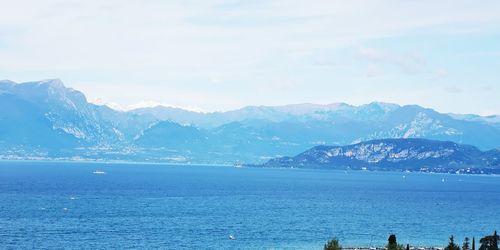 Scenic view of sea and mountains against sky