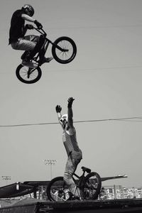 Man riding bicycle on street against sky