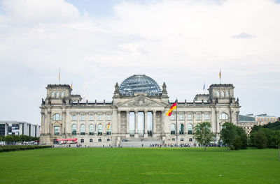 Facade of reichstag building against cloudy sky