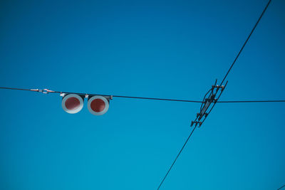 Low angle view of light bulbs against blue sky