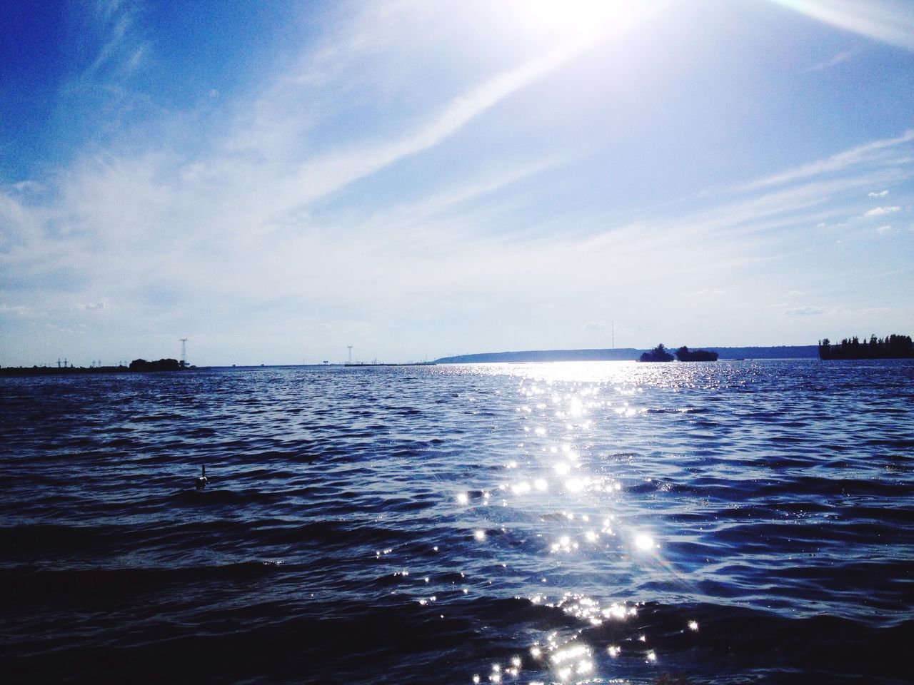 water, sea, waterfront, tranquil scene, sky, scenics, tranquility, blue, beauty in nature, rippled, sunlight, nature, reflection, sun, sunbeam, idyllic, cloud - sky, outdoors, horizon over water, day