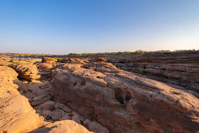 Rock formations on landscape against clear sky