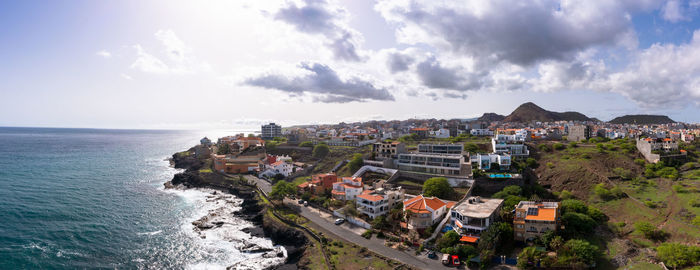 High angle view of townscape by sea against sky
