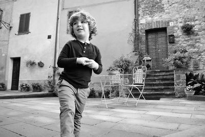 Boy standing against building