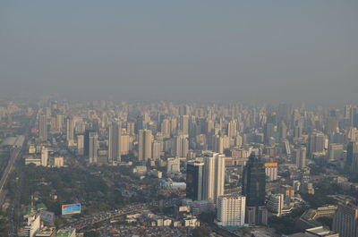 Aerial view of buildings in city against clear sky