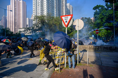 People on street against buildings in city