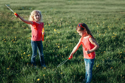 Girls on field against sky