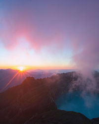 Scenic view of volcano crater and mountains against sky during sunrise