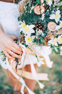 Close-up of woman holding white flowering plant