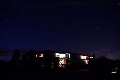 Illuminated buildings against sky at night