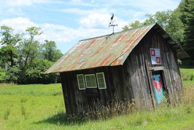 Abandoned house on field against sky