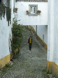 Rear view of woman walking amidst buildings