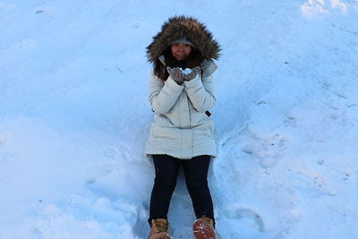 Portrait of woman standing on snow covered land