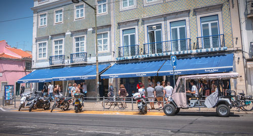 People on street against buildings in city