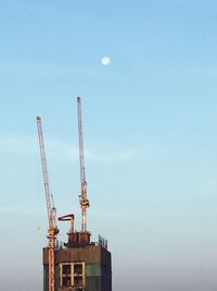 Low angle view of crane against sky