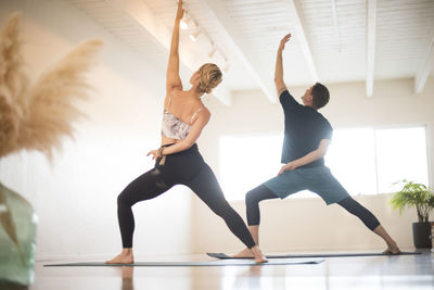 A couple in reverse warrior pose during yoga.