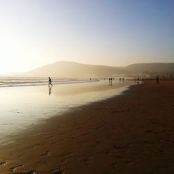 Man standing on beach against clear sky