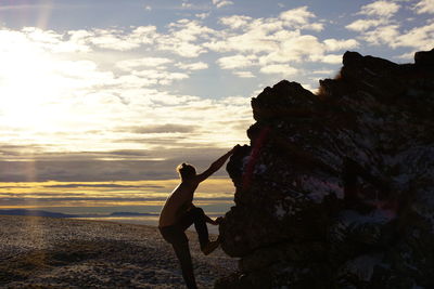 Lone man rear view of man standing on beach against sky during sunset