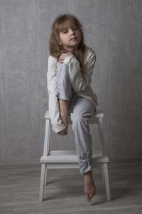 Portrait of girl sitting on step ladder