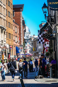 People walking on street against buildings in city