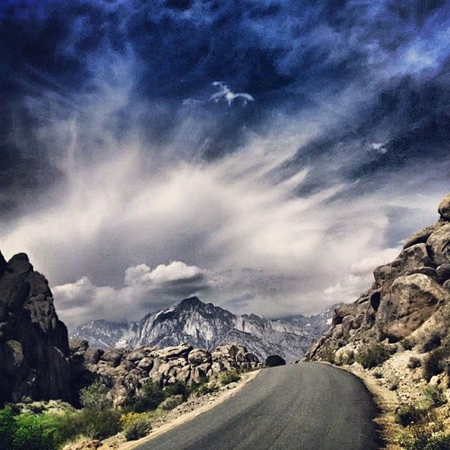 mountain, sky, tranquil scene, tranquility, scenics, the way forward, road, beauty in nature, nature, rock formation, landscape, cloud - sky, mountain range, rock - object, non-urban scene, transportation, cloudy, cloud, diminishing perspective, remote